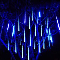 Niebieskie lampki LED meteory w formie świecących sopli na drzewie